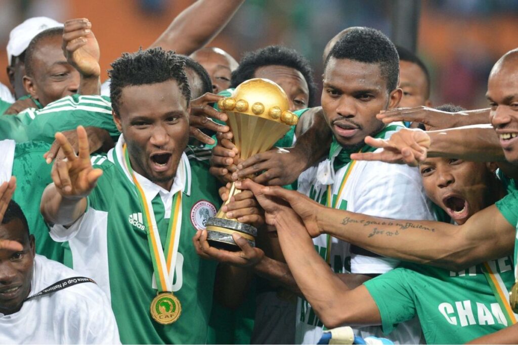 Mikel Obi and Joseph Yobo celebrating Nigeria's 2013 AFCON win. with the squad and technical staff. 